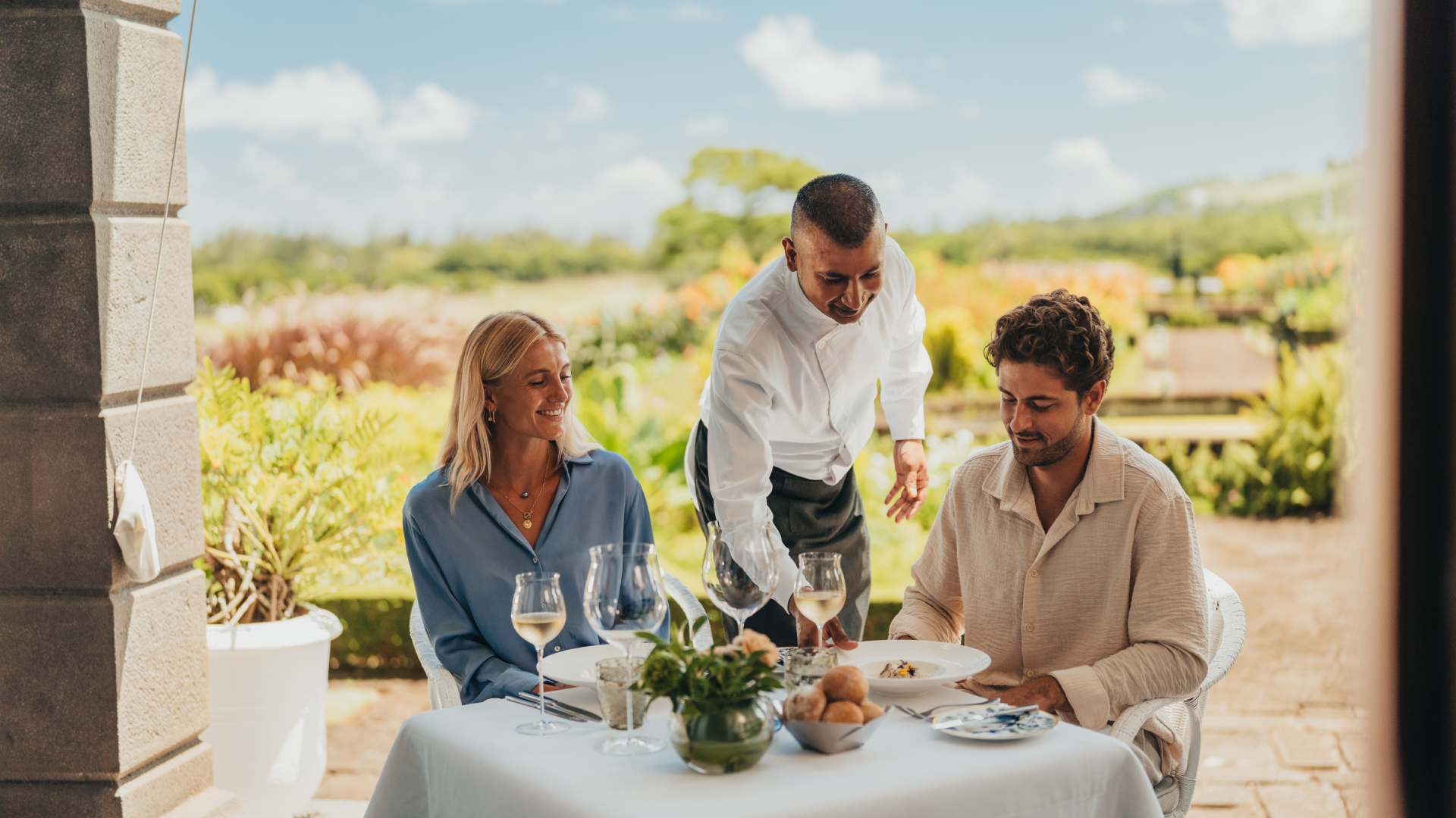 Couple enjoying an elegant lunch experience at Le Château de Bel Ombre in a refined outdoor dining setting.