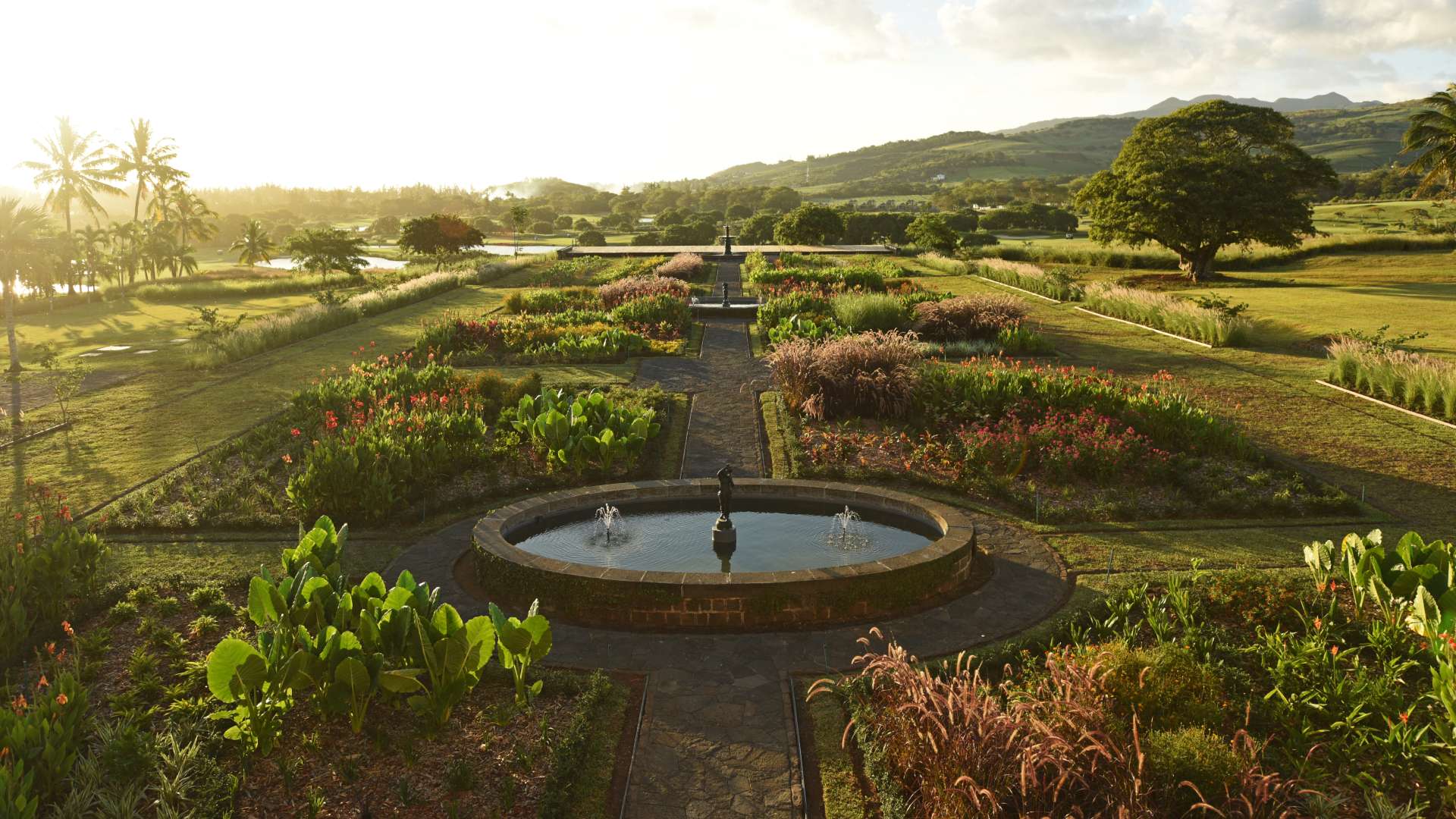 French-style garden and fountain in front of Le Château de Bel Ombre