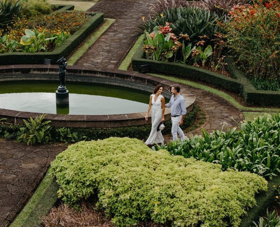 Couple enjoying a romantic walk through the garden of Le Château de Bel Ombre
